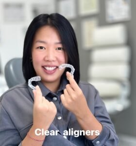 A patient holding her clear aligners